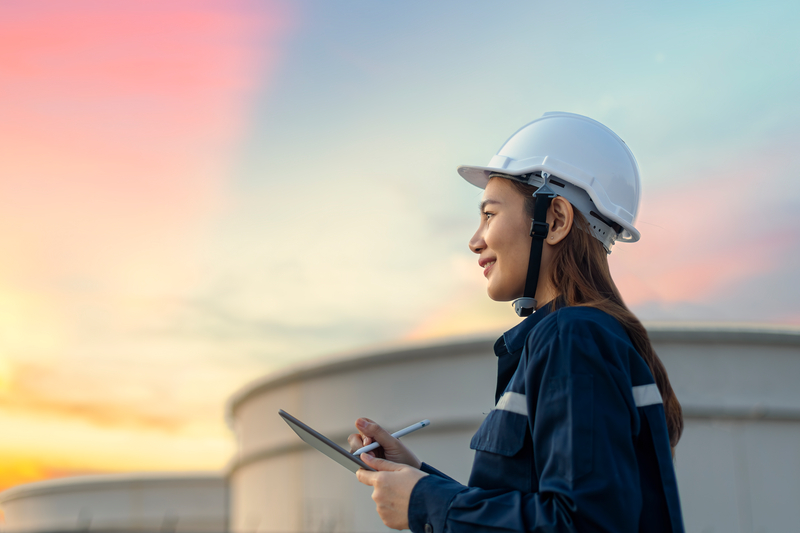 Petroleum oil refinery engineer worker in oil and gas industrial with personal safety equipment PPE to inspection follow checklist by tablet. Classic Energy business concept.